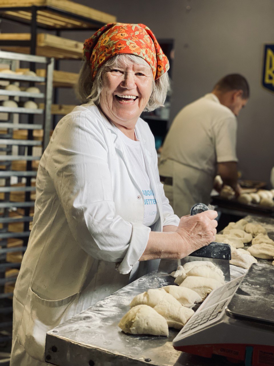 A smiling volunteer portioning dough in the bakery